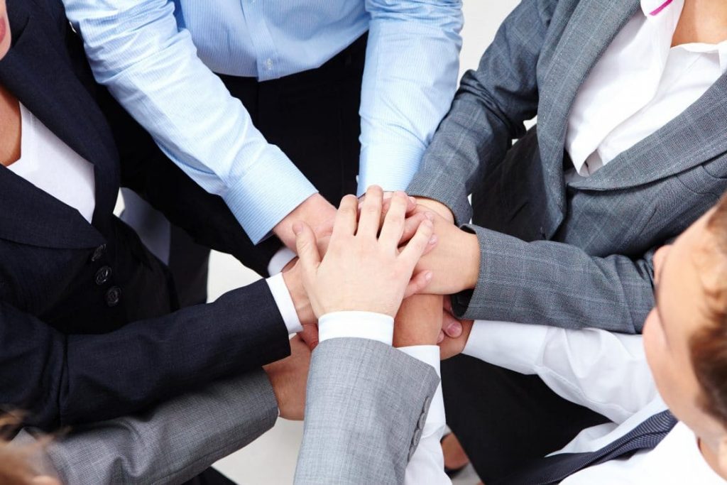 Image of business people hands on top of each other symbolizing support and power