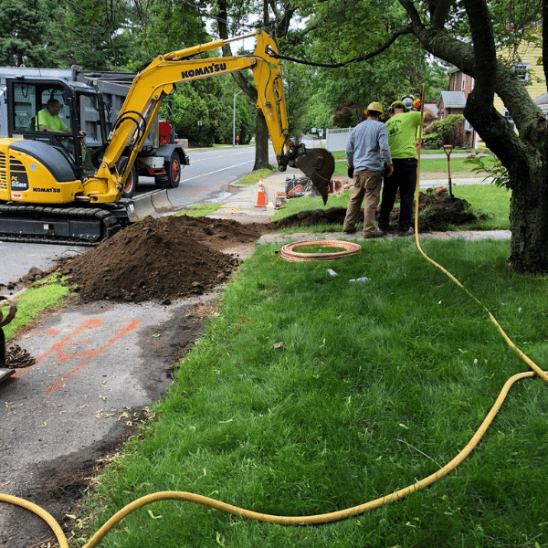 Lead service replacement program in Newton, MA. Excavator and men.