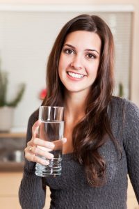 woman with water glass smiling
